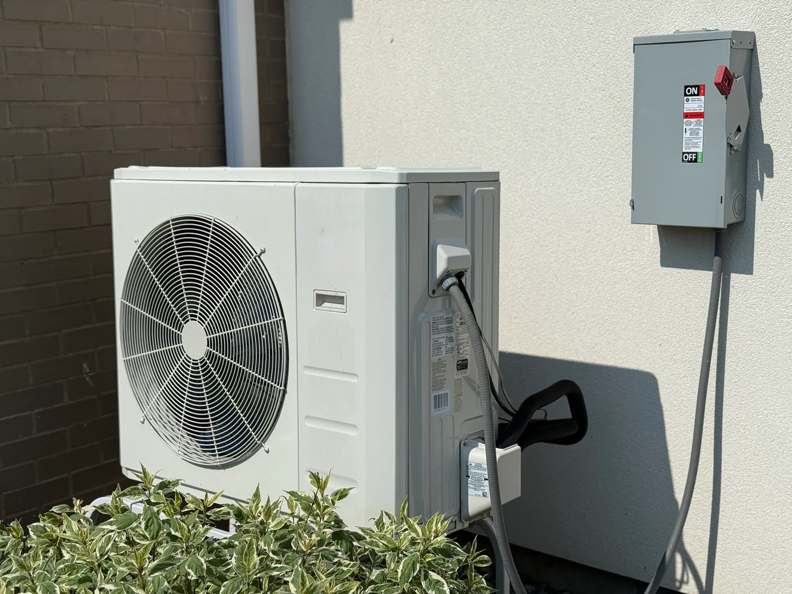 HVAC technician inspecting a heat pump system outdoors